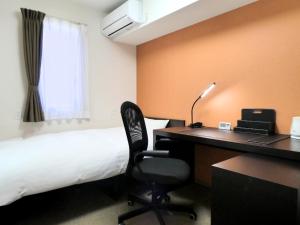 东松岛东松岛矢本最佳价值酒店 的酒店客房配有一张床和一张带电脑的书桌