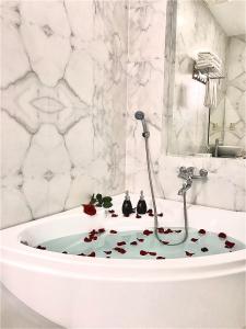 岘港Anh Nguyet Da Nang Hotel的浴室配有浴缸,地板上装饰着花卉