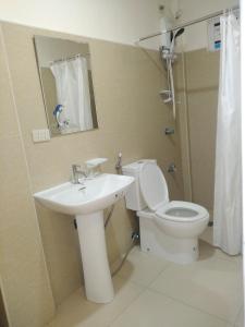 黎牙实比Thirdys Tourist Inn的一间带水槽、卫生间和镜子的浴室
