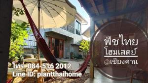 清刊พืชไทยเชียงคาน(Plantthai)的房屋前的标志,上面有吊床和遮阳伞