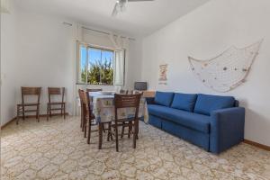贝瓦尼亚圣彼得Casa Bouganville by BarbarHouse的客厅配有蓝色的沙发、桌子和椅子