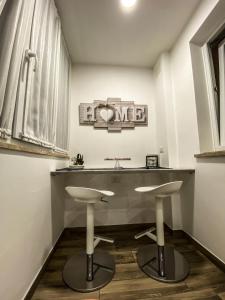 罗马Exclusive Mood Apartment的一间带水槽和两个凳子的浴室
