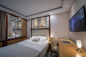 贝尔格莱德Putnik Inn Belgrade的酒店客房设有一张床、一张书桌和一台电视机。