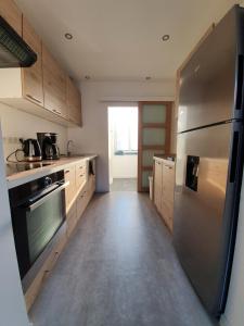 杜埃Appartement calme, chaleureux et lumineux的厨房配有不锈钢冰箱和木制橱柜