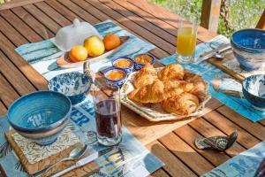 朗布依埃Les Prunelliers的一张桌子,早餐包括羊角面包和橙汁