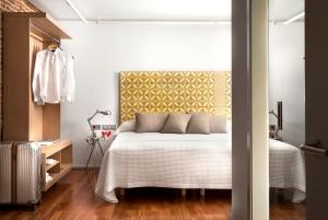马德里埃里克佛克尔精品公寓酒店 - 马德里套房的一间卧室配有一张黄色床头板的床