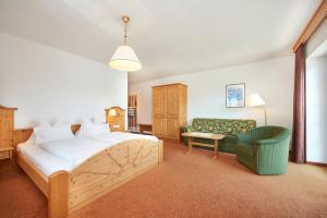 阿特湖畔翁特拉赫Hotel Stadler am Attersee的一间卧室配有一张床和一把绿色椅子