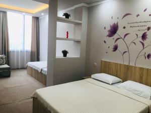 科布列季Riva的卧室配有两张床,墙上挂着紫色的鲜花