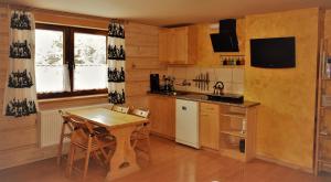 扎科帕内Apartament Fiedorówka的厨房配有木桌和小桌子及椅子
