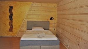 扎科帕内Apartament Fiedorówka的卧室配有一张床铺,位于带木墙的房间内