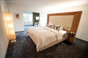 蒂罗尔-泽费尔德克里斯蒂娜酒店的一间卧室配有一张大床和木制床头板