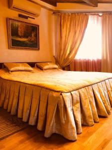 乌日霍罗德查瑞达酒店的卧室内的一张大床,设有窗户