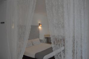 塔维拉塔维拉度假公寓的一间卧室配有白色窗帘的床