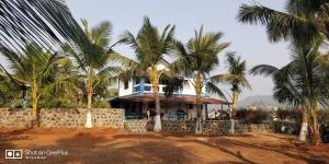 穆鲁德Aqua Arina Holiday Farm House的前面有棕榈树的房子