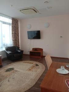喀山Azalya Hotel的客厅配有黑椅和电视