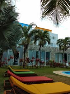 普拉亚多斯卡内罗斯Apart Hotel Praia dos Carneiros Apto 101的建筑物前面的一排五颜六色的长椅