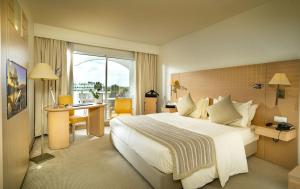斯法克斯Occidental Sfax Centre的酒店客房设有一张大床和一张书桌。