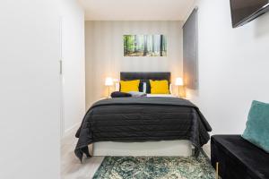 马德里Madrid Rio Apartment的一间卧室配有黑色的床和黄色枕头