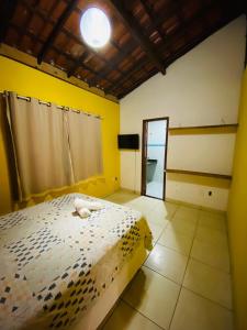安格拉杜斯雷斯Alto do Marinas的一间卧室设有一张床和黄色的墙壁