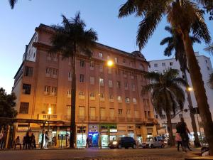 贝洛奥里藏特美洲南宫酒店的一条街道前方有棕榈树的大建筑