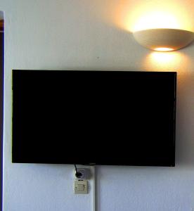 皮索利瓦迪Elena Studios & Apartments的墙上的平面电视,光线充足