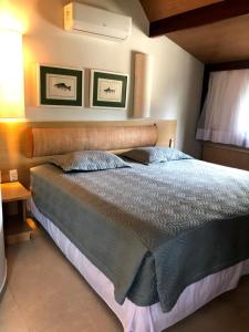 嘎林海斯港Bangalô Luxo Beach Class Resort Muro Alto的一间卧室配有一张大床和木制床头板