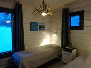 乌茨约基Lomatärppi的一间卧室设有两张床、一个窗户和一个吊灯。