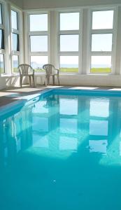 法蒂玛马德琳诺特城堡酒店的一个带两把椅子的游泳池,海水淡蓝色