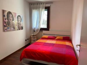 Fiesso dʼArticoAppartamento Girasole tra Padova e Venezia的一间卧室配有一张带彩色毯子的床