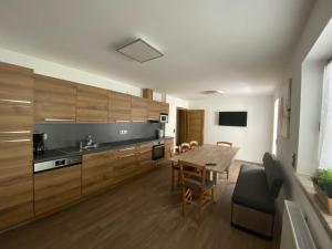 图克斯码头膳食公寓的厨房配有木制橱柜和桌椅