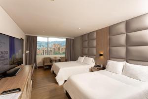 麦德林圣费尔南多广场酒店 的酒店客房设有两张床和一台平面电视。
