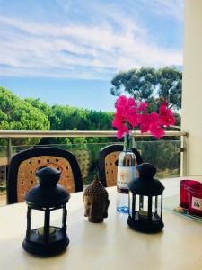 奥霍斯德古阿Delightful vacations apartment in Algarve的一张桌子,上面放着一瓶葡萄酒和鲜花