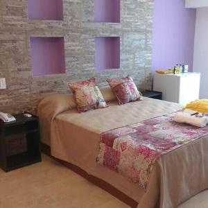 科连特斯NEFERET Habitaciones Temporarias的一间卧室设有一张床和砖墙