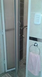 科连特斯NEFERET Habitaciones Temporarias的玻璃门淋浴和毛巾