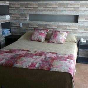 科连特斯NEFERET Habitaciones Temporarias的一间卧室设有一张带砖墙的大床