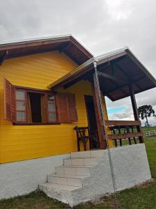 邦雷蒂鲁Cabana Caminho das Borboletas的前面有楼梯的黄色房子