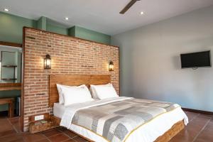 吉利特拉旺安Belukar Villas的一间卧室设有砖墙和一张床