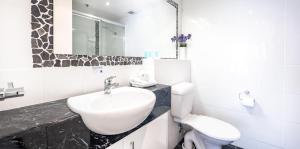 黄金海岸维多利亚广场酒店式公寓的白色的浴室设有水槽和卫生间。