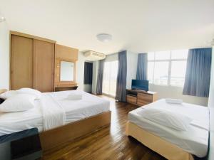 曼谷城市公寓酒店的酒店客房设有两张床和电视。