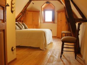 贝纳克和卡泽纳克Maison O'Galop的一间卧室设有一张床、一个窗口和一把椅子