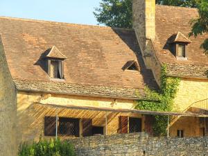 贝纳克和卡泽纳克Maison Linol的一座带窗户和屋顶的旧砖砌建筑