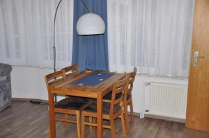 巴尔特鲁姆Seevilla Wietjes Whg 4的餐桌、四把椅子和一盏灯