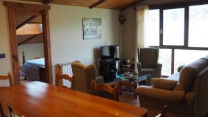 艾扎那扎堡伊克瓜乡村旅馆的客厅配有木桌和电视。