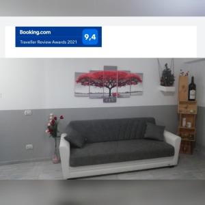 维罗纳Casa Mia的客厅的沙发,配有红色花卉绘画