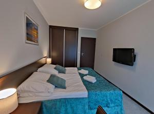科沃布热格Apartament przy hotelu Aquarius的一间卧室设有一张大床和一台平面电视。
