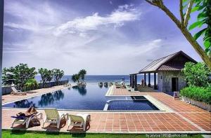 Ban Na DanKhanom Beach Residence Sea & Mountain View - 1 Bedroom的一个带椅子的游泳池,背景是大海