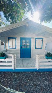 穆里吉奥尔Manu B&B的一间白色的小房子,设有蓝色的门