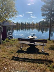 NattavaaraWilderness in off-grid cabin in Lapland的湖前的公园长凳