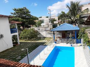 塞拉Pousada do caju的一座带凉亭的蓝色游泳池位于房子旁边