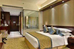艾哈迈达巴德艾哈迈达巴德城中心皇冠假日酒店的一间带大床的卧室和一间浴室